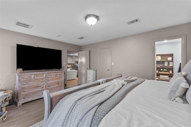 bedroom featuring hardwood / wood-style flooring and a textured ceiling