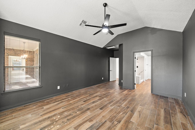 interior space featuring a textured ceiling, vaulted ceiling, and ceiling fan