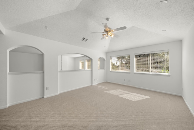 unfurnished room featuring ceiling fan, light colored carpet, a textured ceiling, and vaulted ceiling