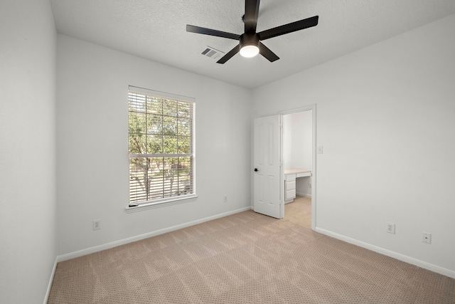 unfurnished room featuring ceiling fan and light carpet