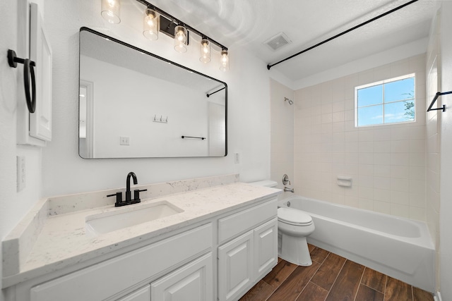 full bathroom featuring vanity, toilet, and tiled shower / bath