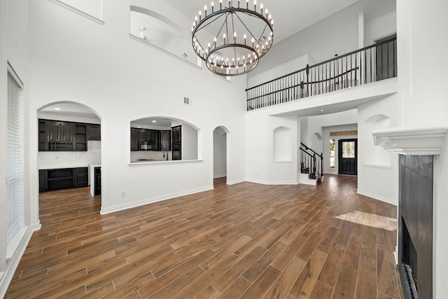 unfurnished living room with a towering ceiling and a chandelier