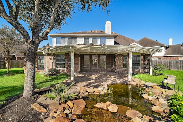 rear view of property with a pergola and a lawn