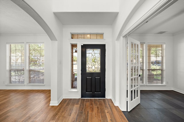 foyer featuring a healthy amount of sunlight, dark hardwood / wood-style floors, and ornamental molding