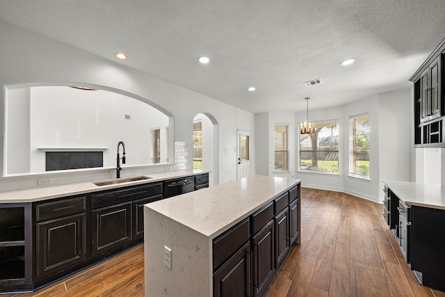 kitchen featuring sink, a center island, a notable chandelier, light hardwood / wood-style floors, and decorative light fixtures