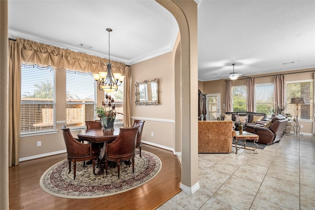 tiled dining area featuring ceiling fan with notable chandelier and ornamental molding