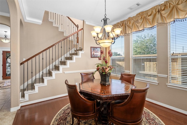 dining space featuring ornamental molding, a notable chandelier, and wood-type flooring