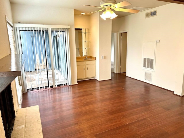 unfurnished living room featuring ceiling fan and dark hardwood / wood-style flooring