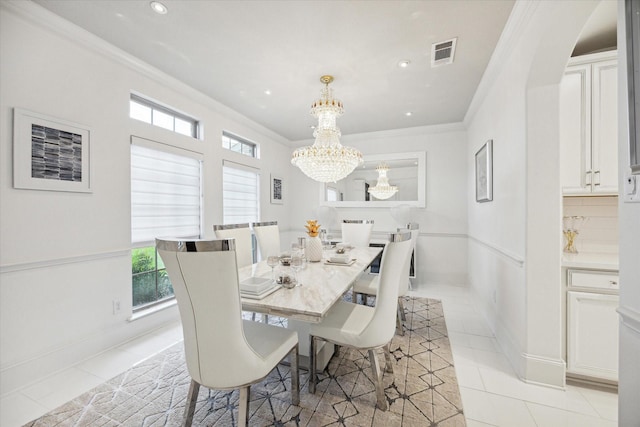 tiled dining room with a notable chandelier and ornamental molding