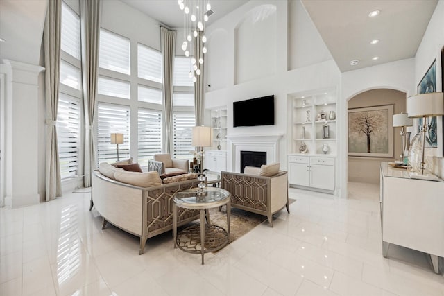 tiled living room featuring built in shelves and a high ceiling