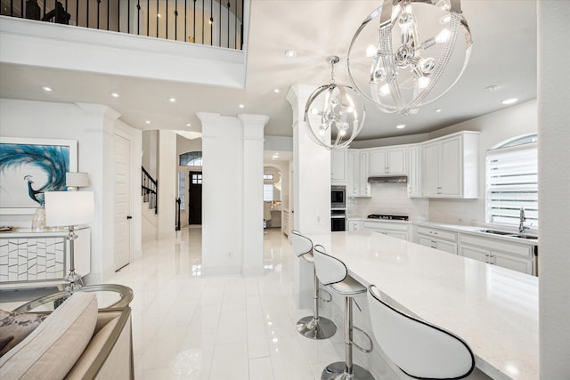 kitchen featuring sink, tasteful backsplash, a chandelier, white cabinets, and appliances with stainless steel finishes