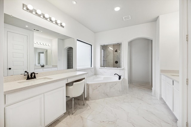 bathroom featuring vanity and independent shower and bath