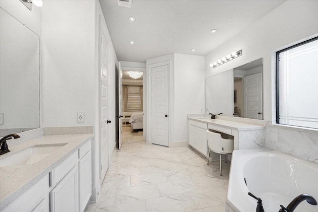 bathroom with vanity and a tub