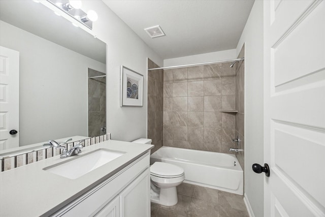 full bathroom featuring vanity, tile patterned floors, tiled shower / bath combo, and toilet