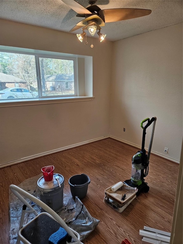 misc room featuring wood-type flooring, ceiling fan, and a textured ceiling