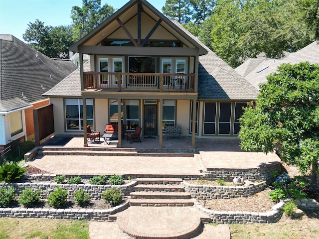 rear view of property featuring a patio and a balcony