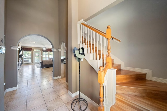 stairs with tile patterned floors and ceiling fan