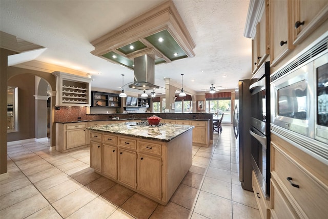 kitchen featuring light stone countertops, ceiling fan, a center island, pendant lighting, and island range hood