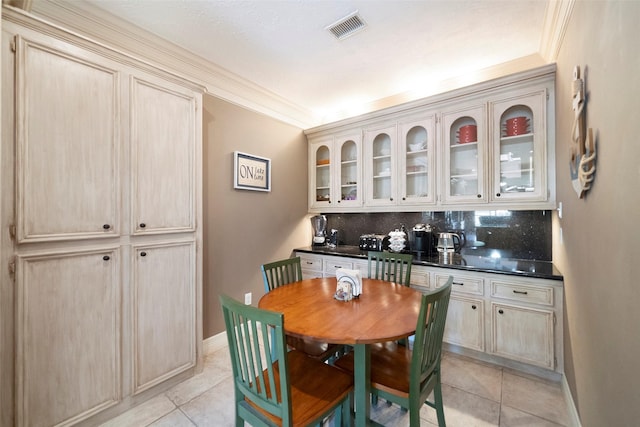 dining room with light tile patterned floors and ornamental molding