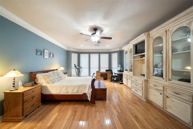 bedroom featuring ceiling fan, crown molding, light wood-type flooring, and a textured ceiling