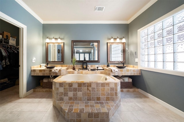 bathroom with tile patterned floors, sink, crown molding, and tiled tub