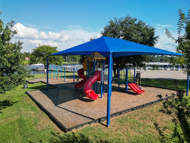 view of playground with a lawn and a water view