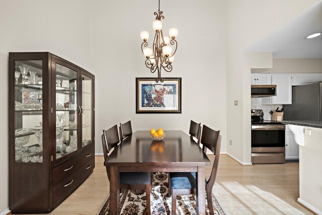 dining area featuring light hardwood / wood-style floors and a chandelier