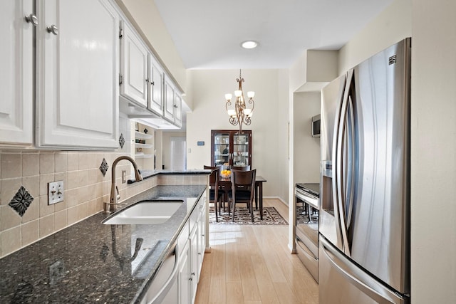 kitchen featuring an inviting chandelier, white cabinets, sink, appliances with stainless steel finishes, and light hardwood / wood-style floors