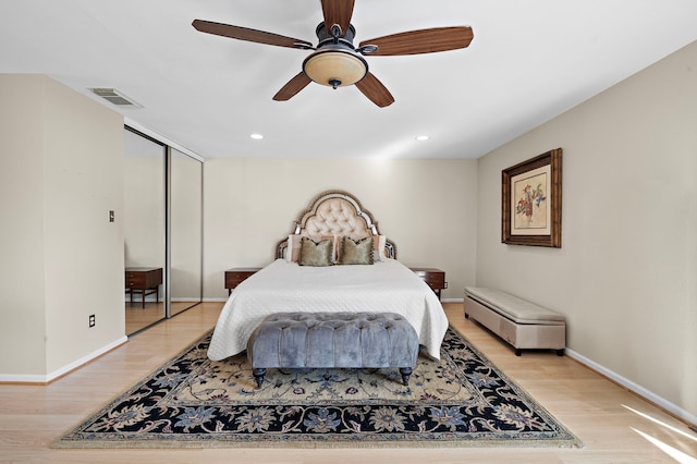 bedroom with ceiling fan, light wood-type flooring, and a closet