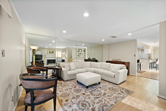 living room featuring light hardwood / wood-style floors and crown molding