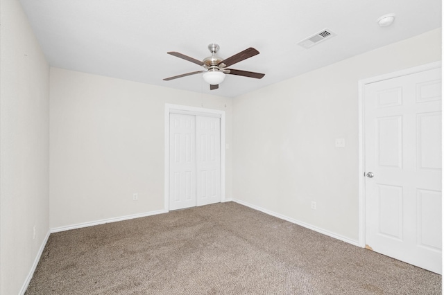 unfurnished bedroom featuring carpet flooring, ceiling fan, and a closet