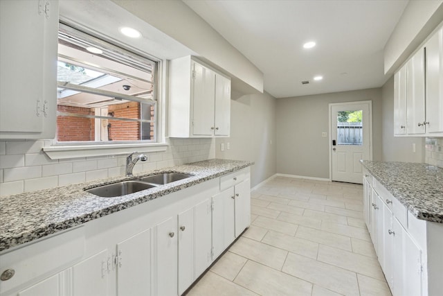 kitchen featuring white cabinetry, sink, and decorative backsplash