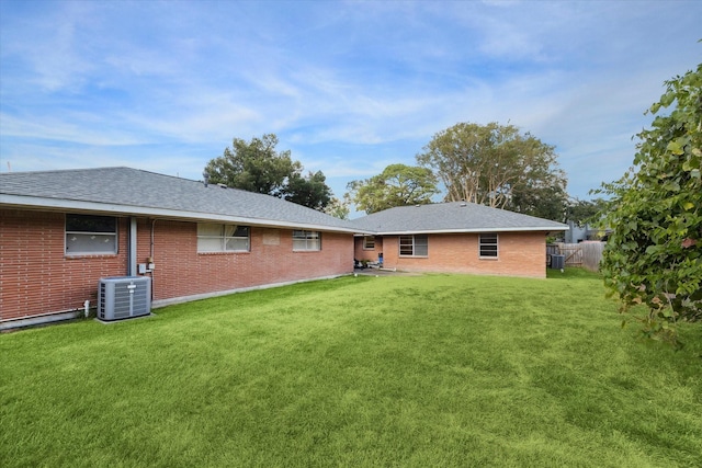 back of house with a yard and central air condition unit