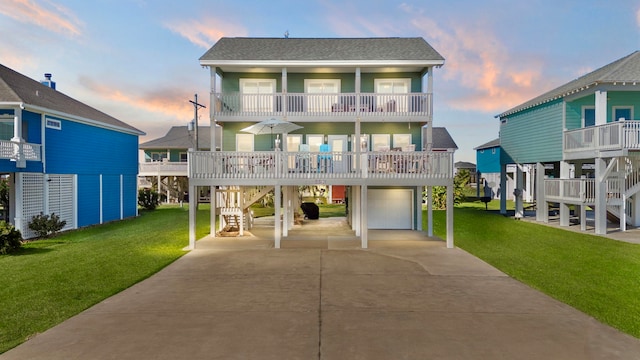 coastal inspired home with a yard, a balcony, a garage, and a carport