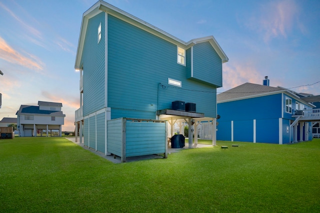 back house at dusk with a lawn