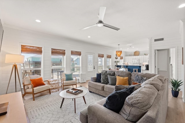 living room with light wood-type flooring and ceiling fan