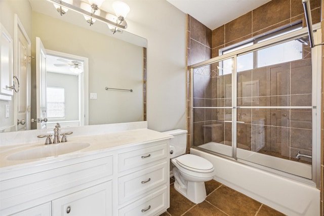 full bathroom featuring tile patterned floors, vanity, ceiling fan, shower / bath combination with glass door, and toilet