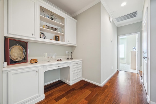 bar featuring white cabinetry, dark wood-type flooring, built in desk, and ornamental molding