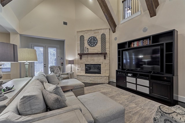 living room featuring a fireplace, wood-type flooring, and high vaulted ceiling