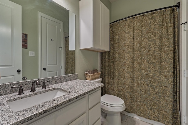 bathroom with tile patterned flooring, vanity, and toilet