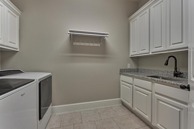 clothes washing area featuring sink, light tile patterned flooring, cabinets, and independent washer and dryer