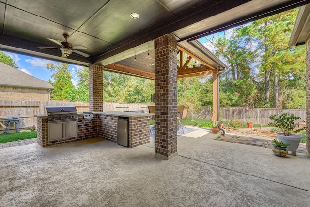 view of patio with an outdoor kitchen, ceiling fan, and a grill