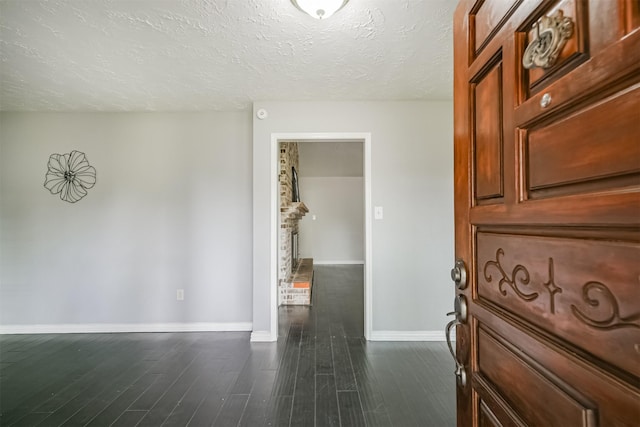 corridor featuring dark hardwood / wood-style flooring and a textured ceiling