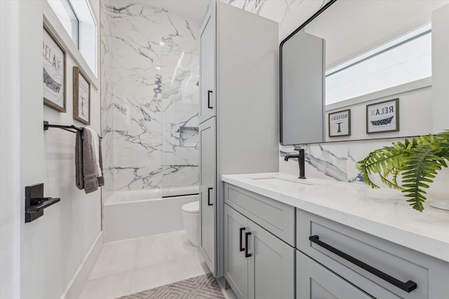 full bathroom with tiled shower / bath, tile patterned flooring, vanity, and toilet