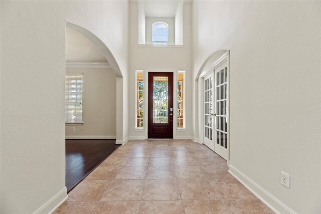 entrance foyer with crown molding and light tile patterned floors