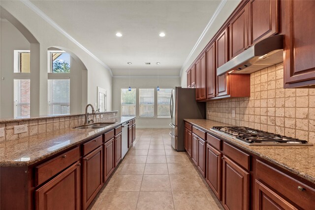 kitchen with crown molding, light stone countertops, sink, decorative light fixtures, and stainless steel appliances