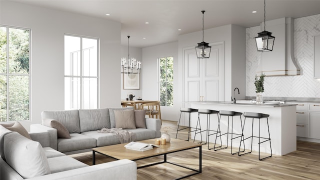 living room with a notable chandelier and light hardwood / wood-style flooring