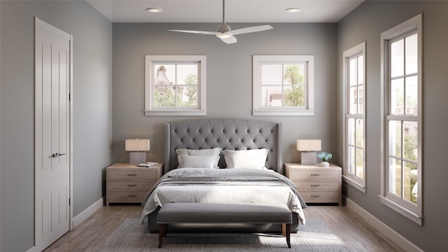 bedroom with multiple windows, light wood-type flooring, and ceiling fan