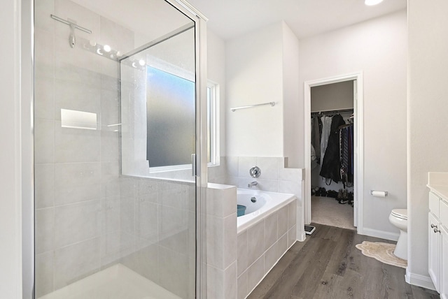 full bathroom featuring hardwood / wood-style flooring, vanity, toilet, and plus walk in shower