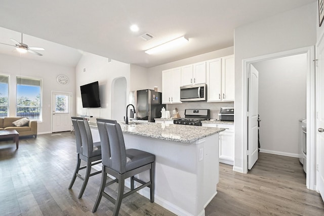 kitchen with a center island with sink, white cabinetry, and appliances with stainless steel finishes